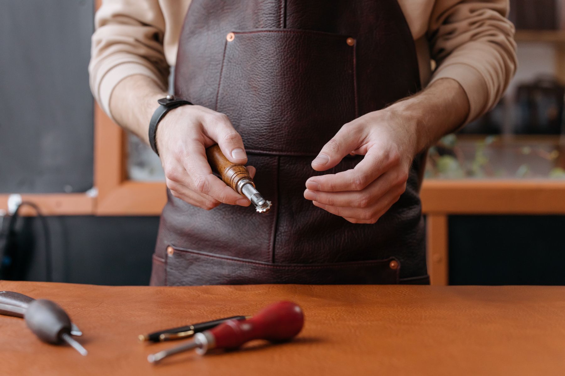 Saddlemaker with leather-working tools
